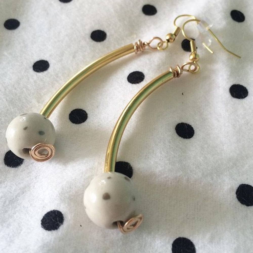 Cute curved gold earrings with porcelain bead